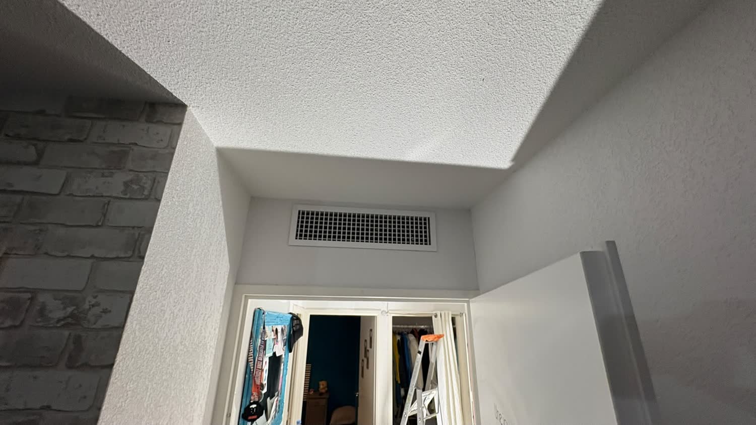 Grille de reprise d'air d'une climatisation gainable intégrée en hauteur dans un appartement