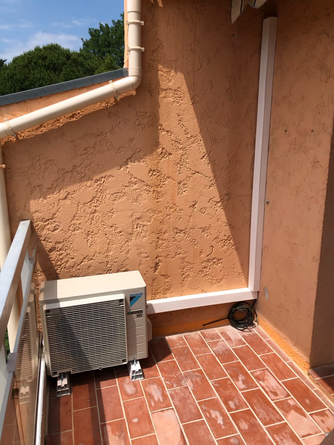 Unité extérieure Daikin installée sur une terrasse en tomettes