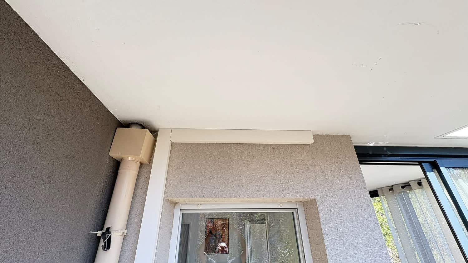 Liaisons frigorifiques d'une climatisation soigneusement masquées au plafond d'une terrasse couverte
