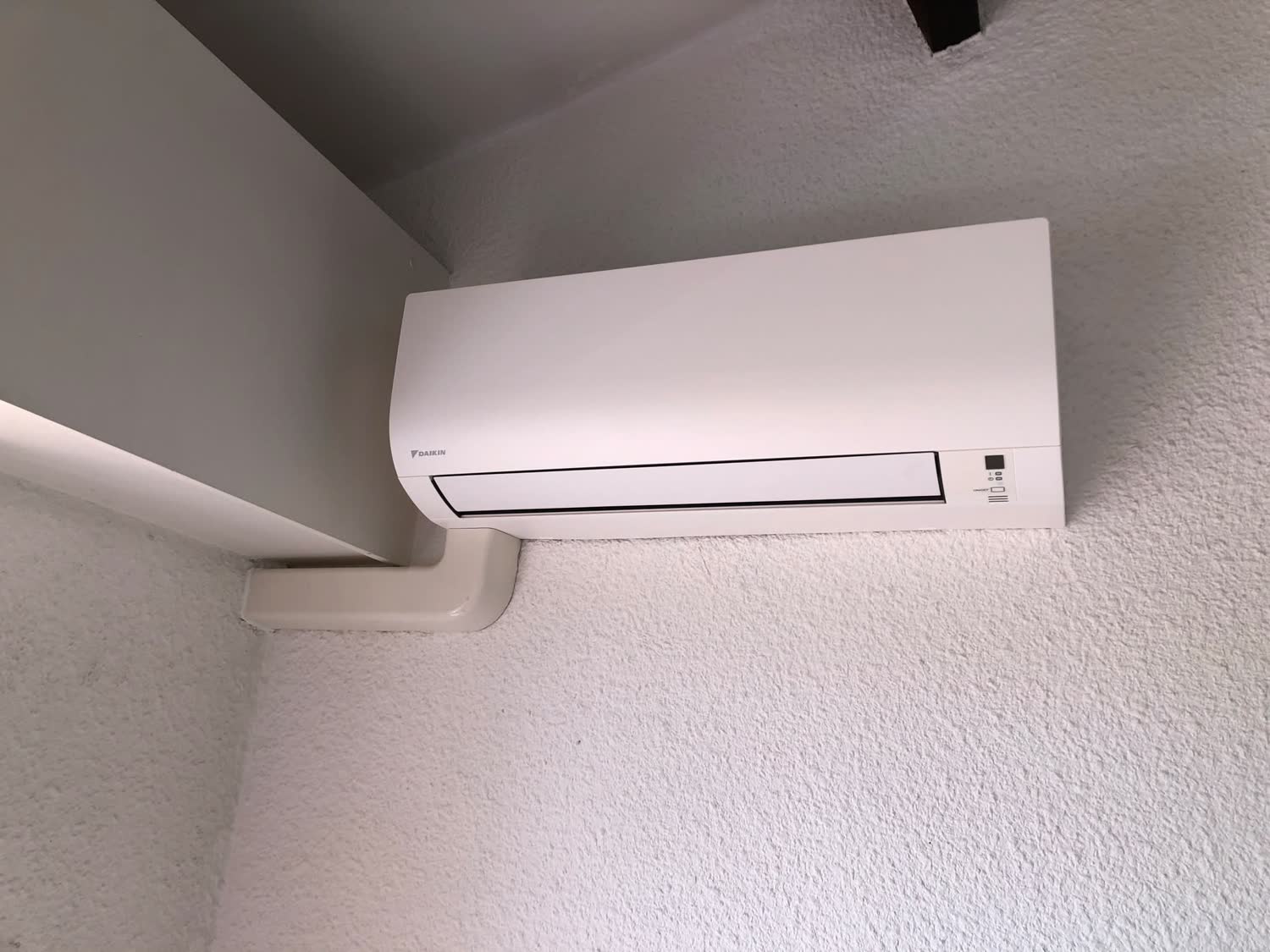 Split mural Daikin posé en angle de pièce avec goulotte de finition